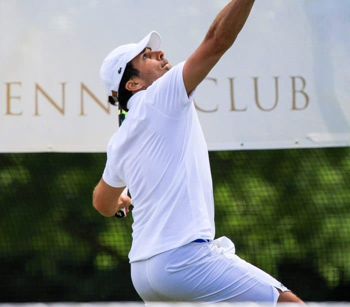 A player mid-serve on a London court