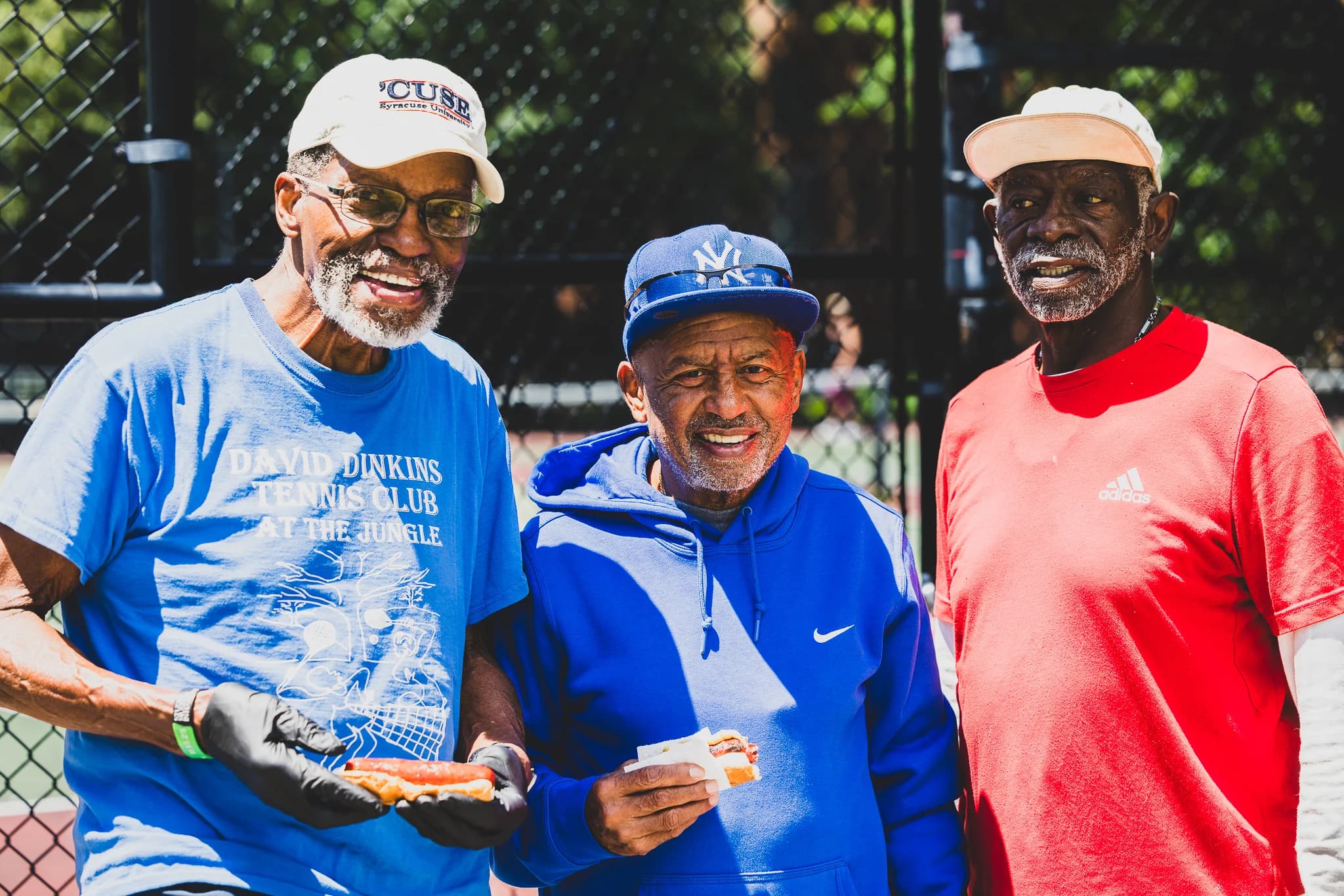 Three long-standing regulars of The Jungle at the fence of Frederick Johnson Playground.