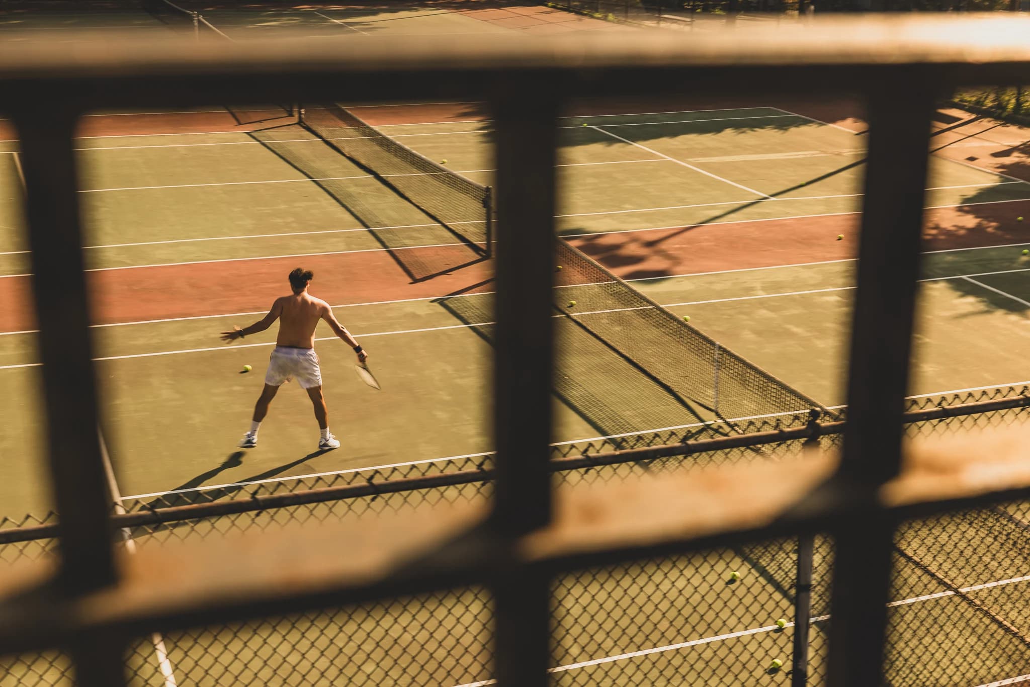 A player on court at Frederick Johnson Playground, seen through the fence.